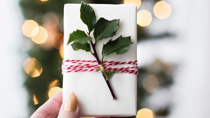 Frau hält Weihnachtsgeschenk in der Hand