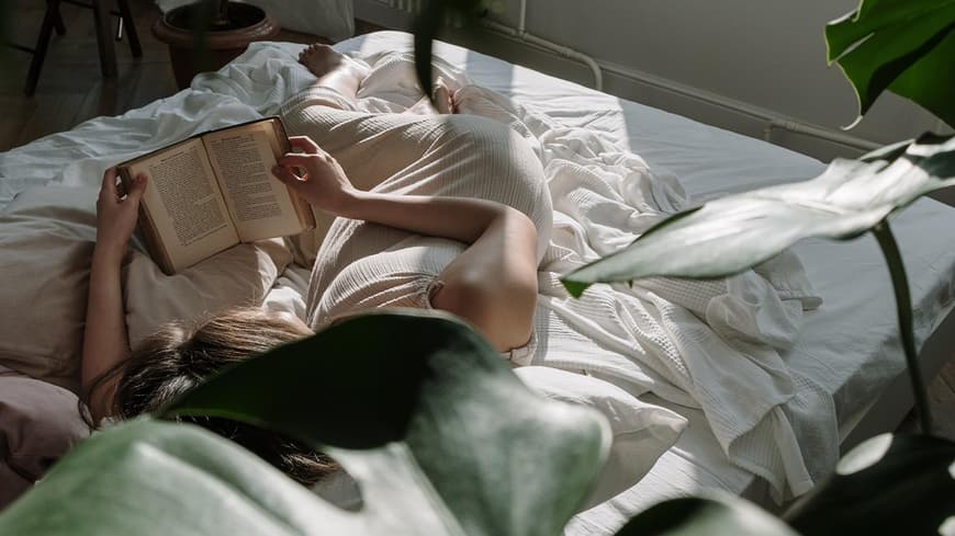 Frau liest Buch im Bett Frau liest Buch im Bett