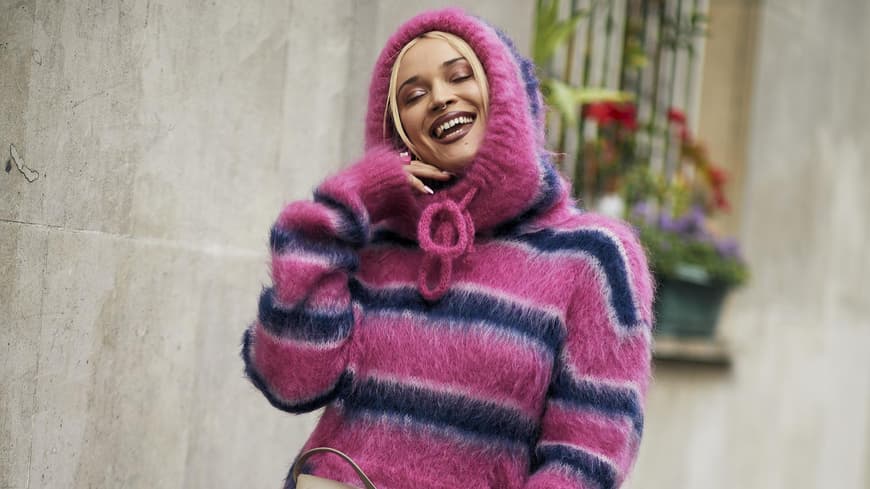 Frau auf Paris Fashion Week im Oversize Strickpullover und Jeansshorts