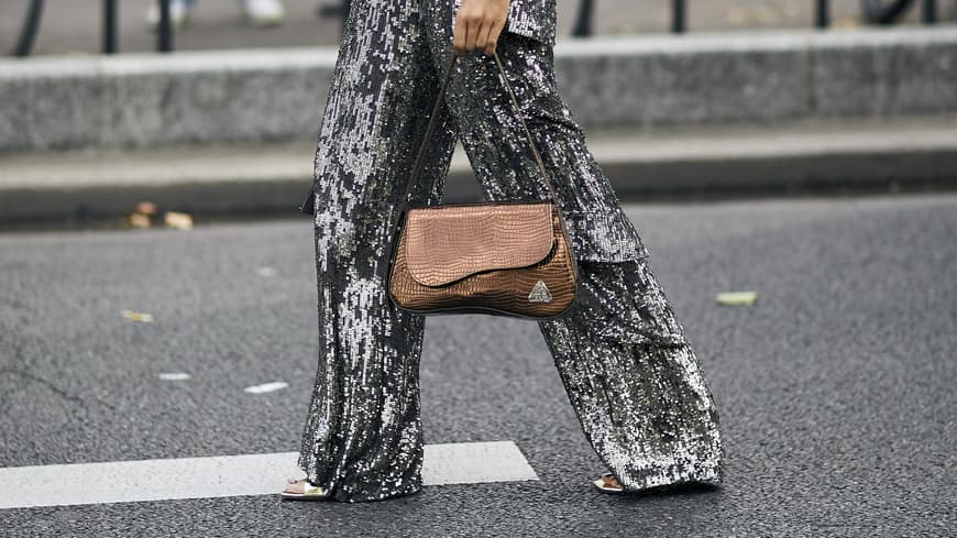 Frau trägt auf Paris Fashion Week schimmernde Hose in Silber