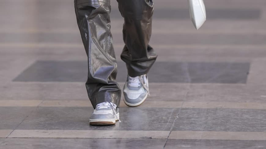 Frau trägt grau-weiße Sneaker