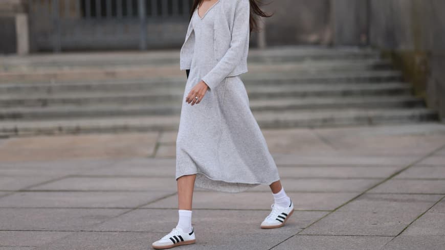 Frau trägt Kleid und weiße Sneaker