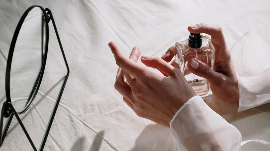 Frau trägt Parfum auf Handgelenk auf Frau trägt Parfum auf Handgelenk auf
