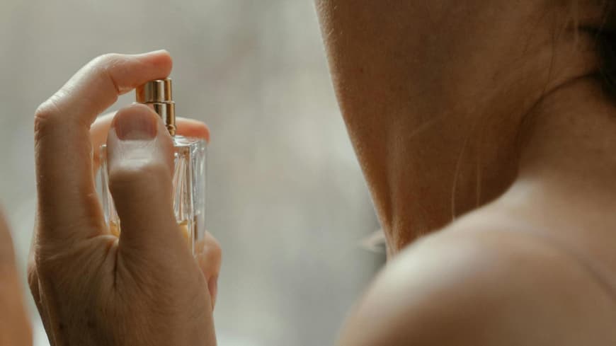 Frau trägt Parfum auf