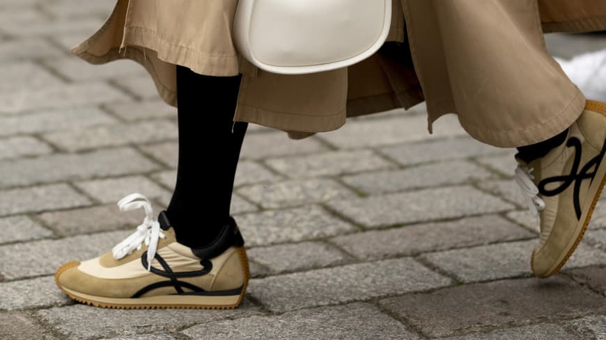 London Fashion Week Frau trägt beigefarbenen Sneaker und Rock
