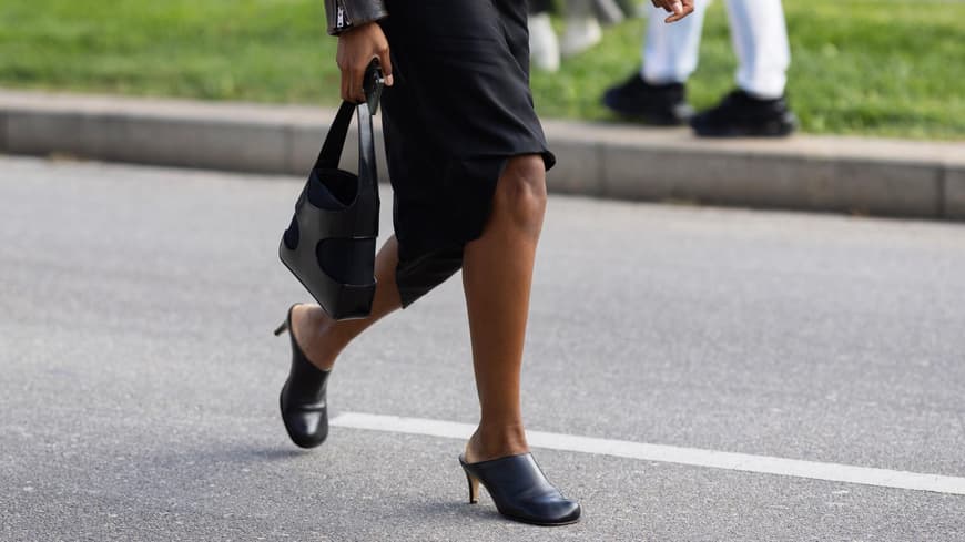 Frau trägt Mules zu schwarzem Kleid