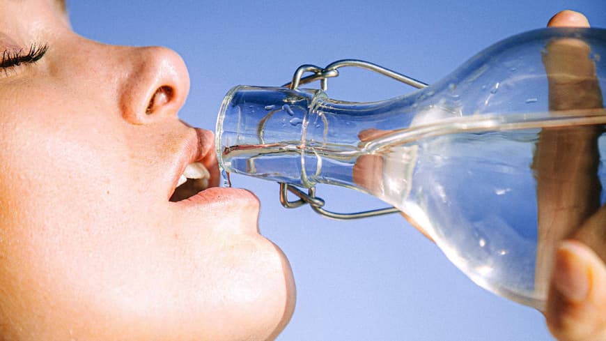 Frau trinkt Wasser aus Flasche