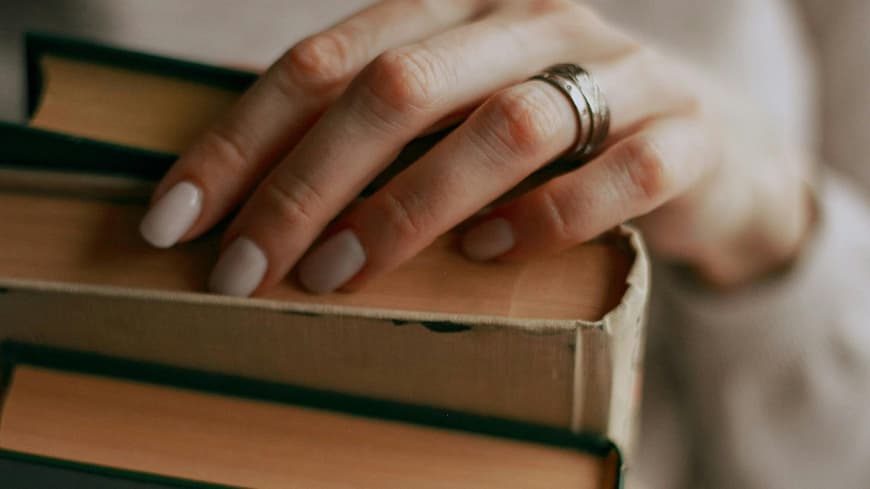 Frau hält drei Bücher in den Händen
