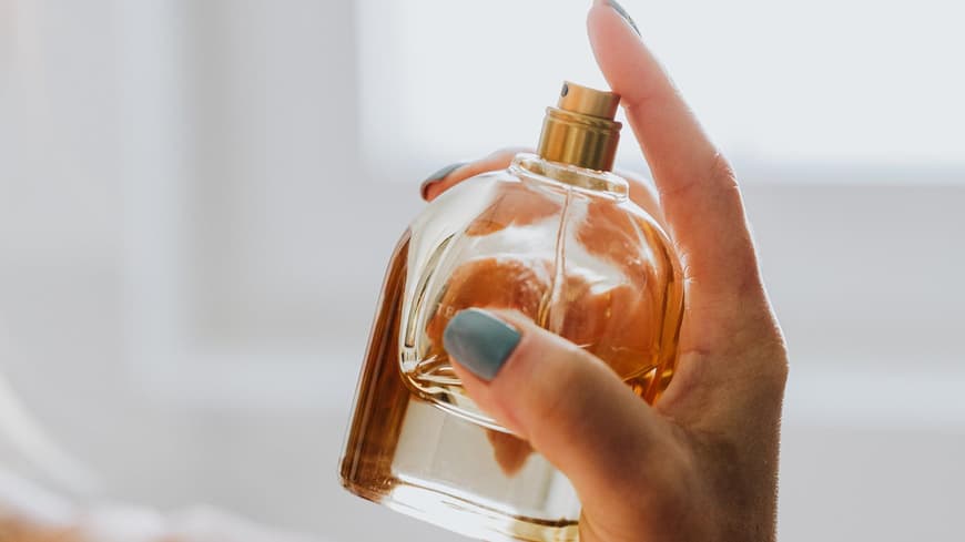 Frau sprüht Parfum auf