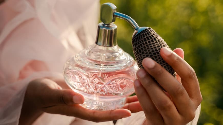 Frau hält Parfum in der Hand