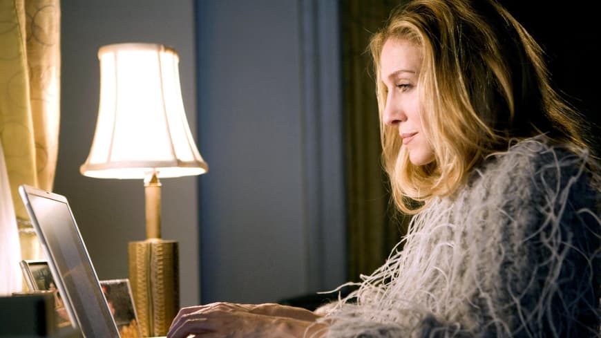 Carrie Bradshaw sitzt vor Laptop
