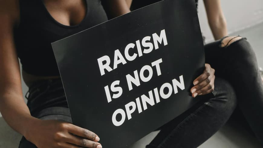 Zwei Frauen mit Schild "Racism is not opinion"