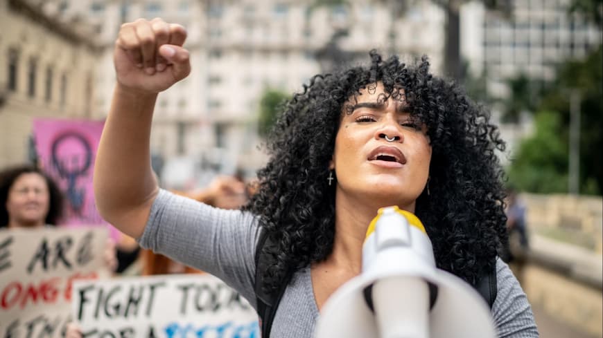 Frau hält Megafon bei Demonstration