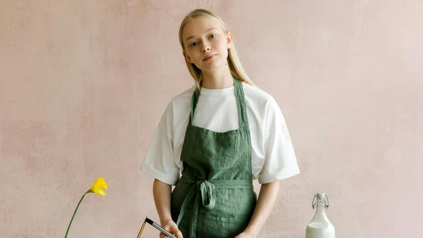 Frau mit grüner Schürze backt Kuchen