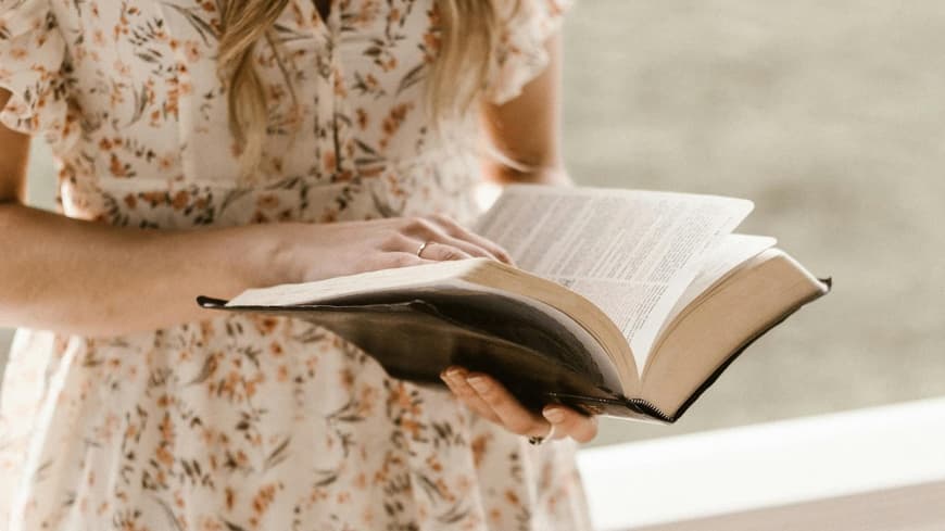 Frau liest Buch auf der Veranda
