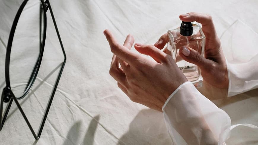 Frau trägt Parfum auf Handgelenk auf Frau trägt Parfum auf Handgelenk auf