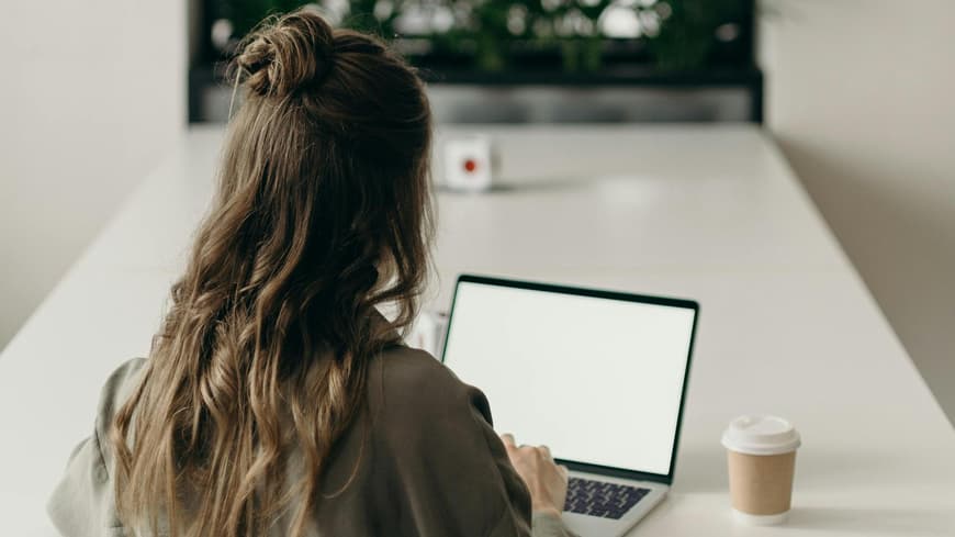 Frau sitzt vor ihrem Laptop