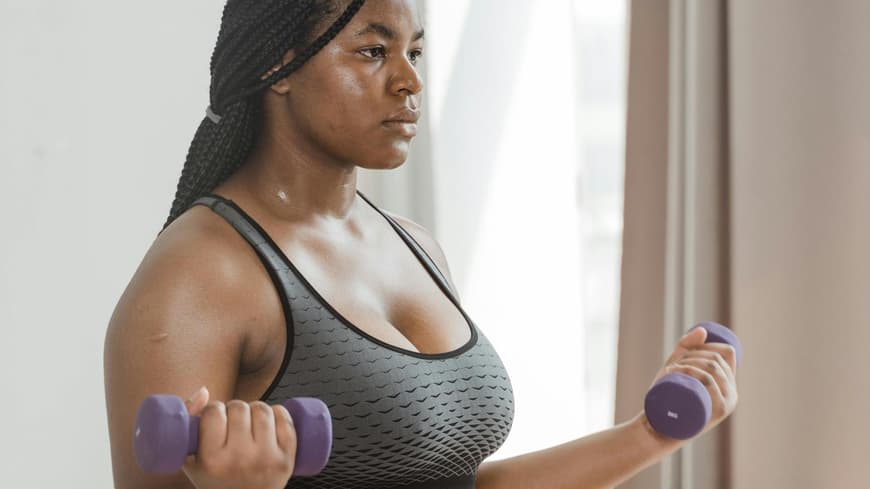 Frau macht "Cozy Cardio" mit Hanteln