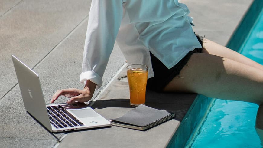 Frau macht "Quiet Vacation" mit Laptop am Pool