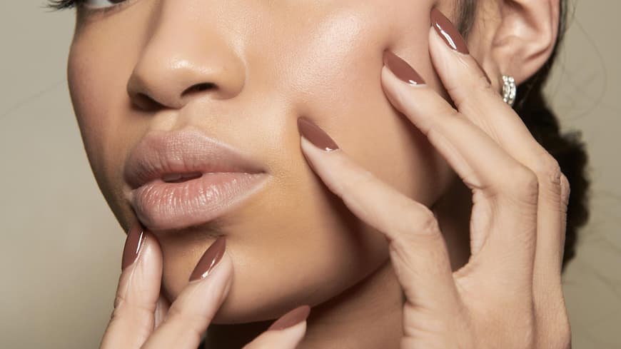 Frau trägt braunen Nagellack