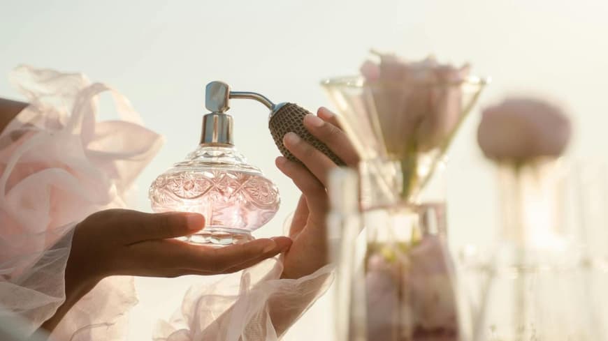 Frau mit einem Parfumflakon in der Hand