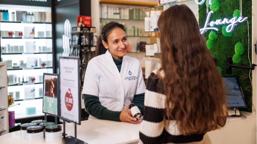 Eine junge Frau steht in der Apotheke