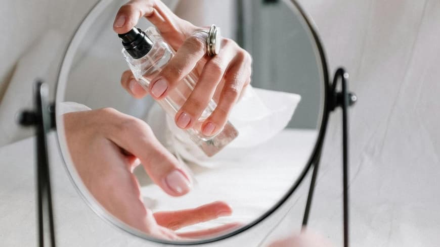 Frau trägt Parfum auf Handgelenk auf