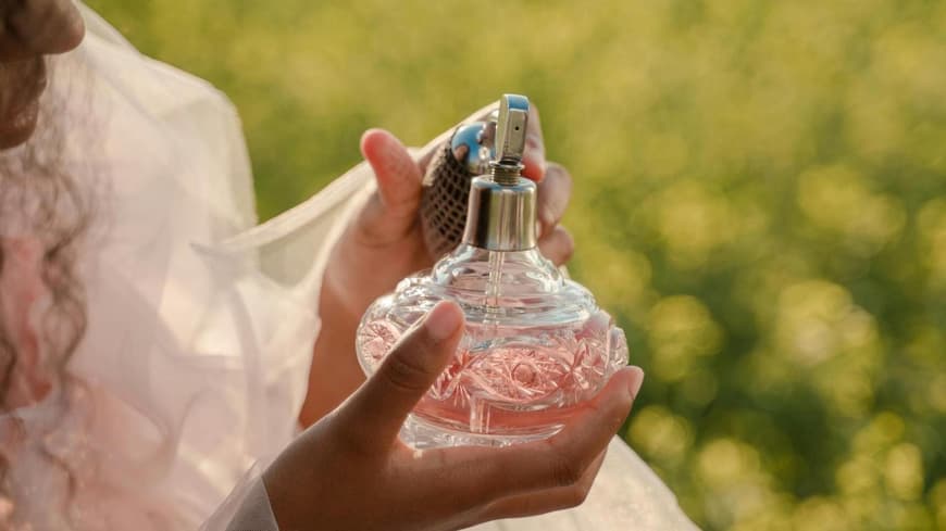 Frau mit Parfum in der Hand