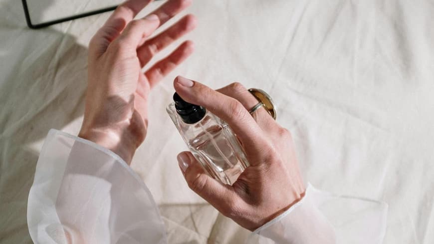Frau sprüht Parfum auf