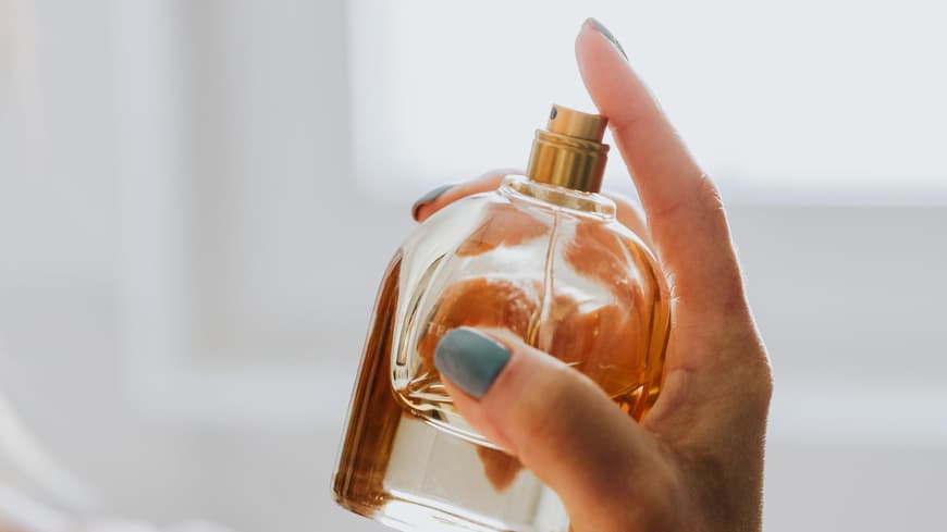 Eine Frau hält einen Duft in der Hand