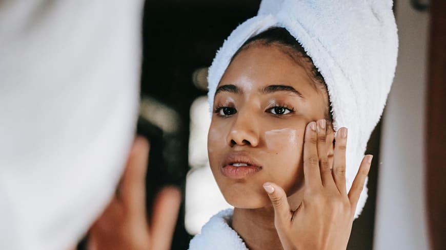 Eine Frau trägt eine Gesichtspflege auf