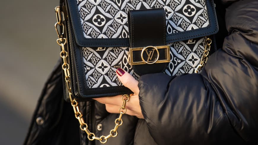 Louis Vuitton Tasche und Hand mit rotem Nagellack