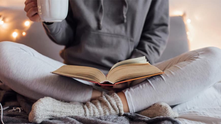Frau im Schneidersitz liest Buch