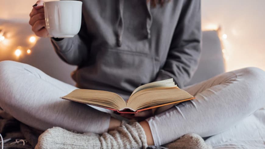 Frau im Schneidersitz liest Buch