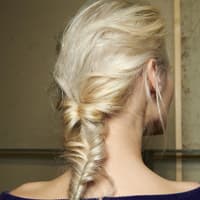 Frau mit blonden Haaren und Fischgrätenzopf