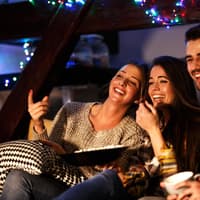 Gruppe sitzt vor Fernseher Lichterkette Freunde Gruppe sitzt vor Fernseher Lichterkette Freunde