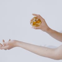 Frau sprüht sich mit Parfum ein Frau sprüht sich mit Parfum ein