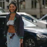 Frau lacht trägt Jeans Look und Jacke Gürtel Sonnenbrille