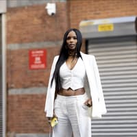 Frau trägt einen weißen Hosenanzug mit Weste