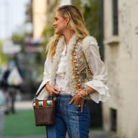 Chiara trägt eine bestickte Weste über eine luftige Bluse