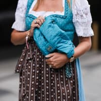 Frau trägt Blaue Chanel-Handtasche zum Dirndl