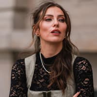 Masha Sedgwick trägt dunkelgrünes Dirndl und schwarze Spitzenbluse und offene Haare mit Wellen Oktoberfest Make-up