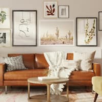 Stilvoll eingerichtetes Wohnzommer mit brauner Couch und Bildern an der Wand