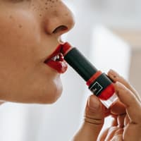 Frau trägt Lippenstift auf