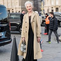 Maye Musk auf Dior Show 2023 mit beigem Trenchcoat und schwarzem Kleid Streetstyle lässige Kleidung für Frauen ab 60