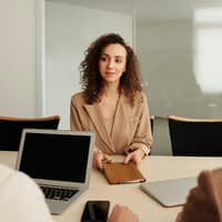 Frau mit lockigen Haaren beim Bewerbungsgespräch