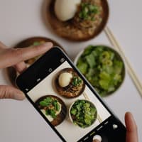Veganes Essen wird mit einem Smartphone fotografiert