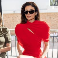 Kylie Jenner auf der Fashion Show von Jacquemus in einem roten Kleid und schwarzer Cat Eye Sonnenbrille Kylie Jenner auf der Fashion Show von Jacquemus in einem roten Kleid und schwarzer Cat Eye Sonnenbrille