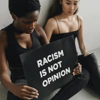 Zwei Frauen mit Schild "Racism is not opinion"