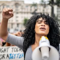 Frau hält Megafon bei Demonstration